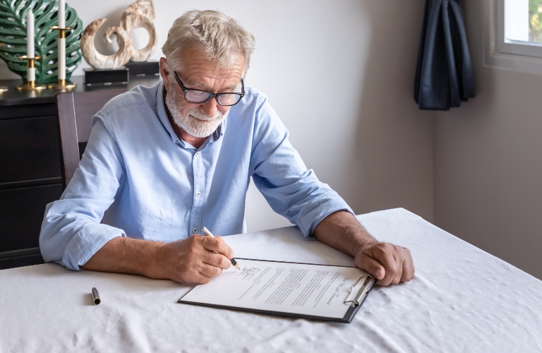 senior man signs documents